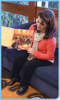 A woman holding a picture book open to display when reading