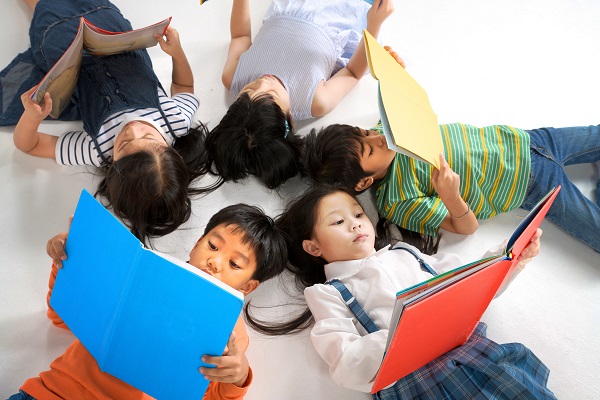 Five children reading on the floor in a star formation